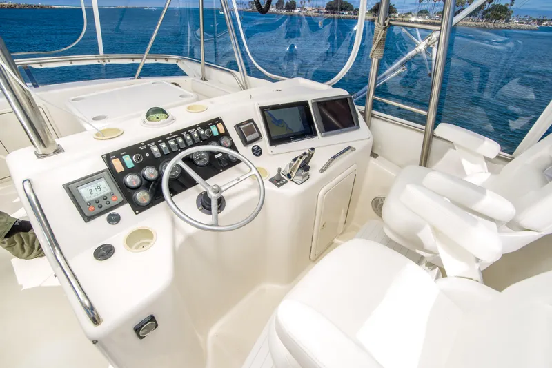 Slide: The Image of 1999 Riviera 43 Open Flybridge helm with steering wheel, controls, and ocean view. - 10