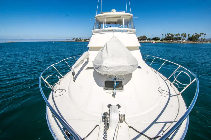 Slide: The Image of 1999 Riviera 43 Open Flybridge yacht on calm blue water, clear sky background. - 6