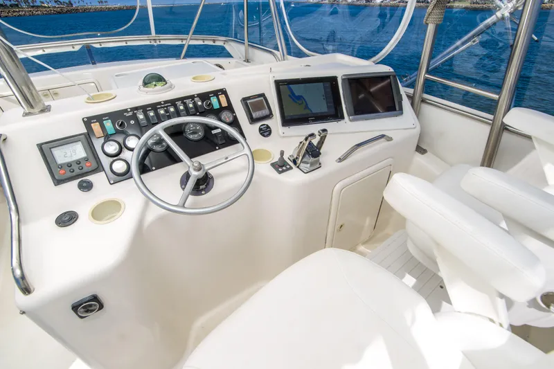 Slide: The Image of 1999 Riviera 43 Open Flybridge helm with steering wheel, controls, and navigation screens. - 9