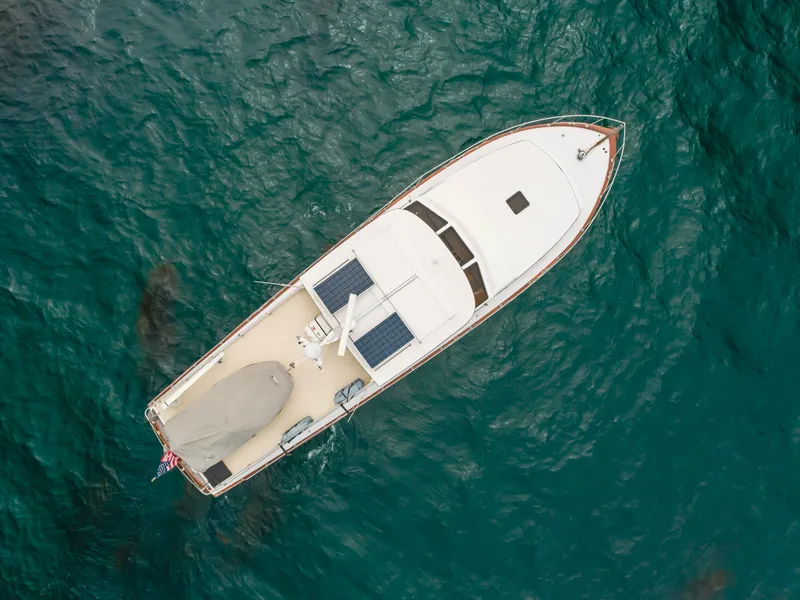 Slide: The Image of Aerial view of 1984 Vic Franck pilothouse boat on blue ocean water. - 11