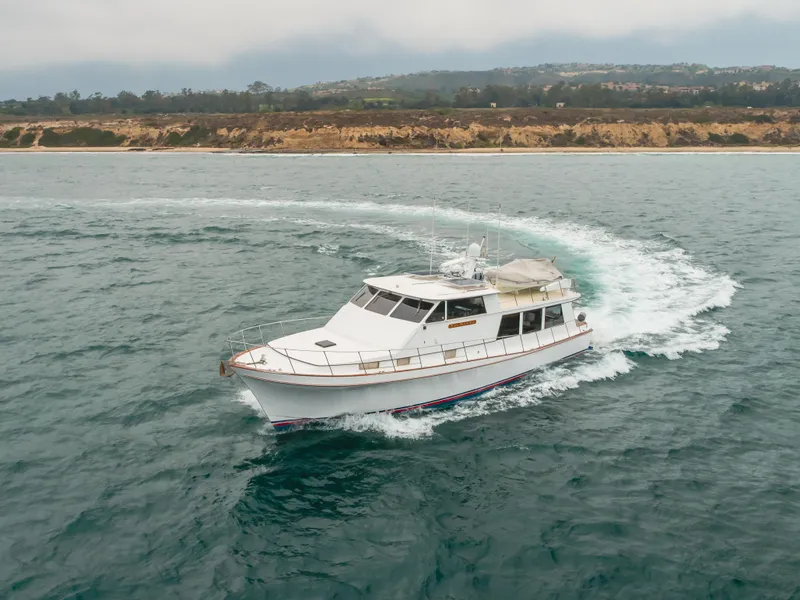 Slide: The Image of 1984 Vic Franck pilothouse yacht cruising near a scenic coastline. - 16