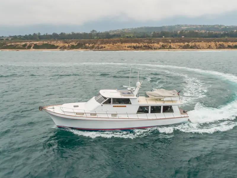 Slide: The Image of 1984 Vic Franck pilothouse yacht cruising on the ocean near a scenic coastline. - 17