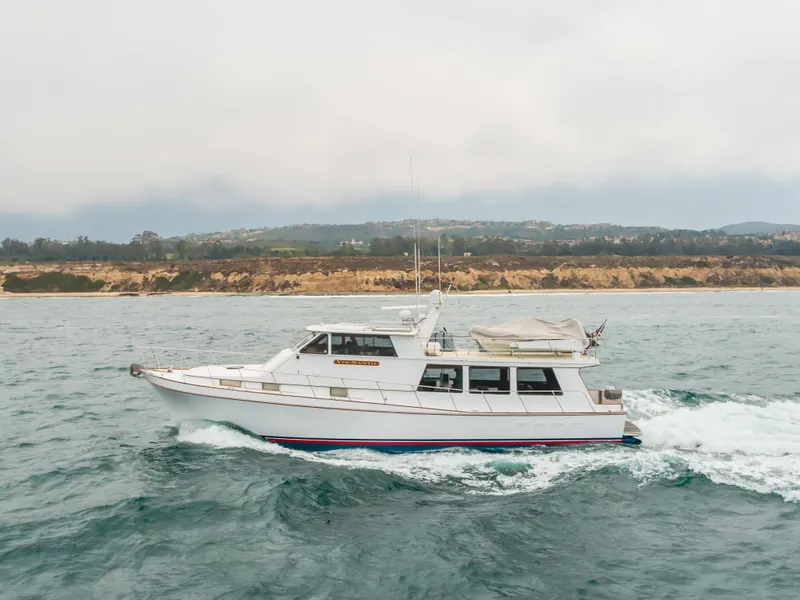Slide: The Image of 1984 Vic Franck pilothouse yacht cruising on the ocean near a scenic coastline. - 18