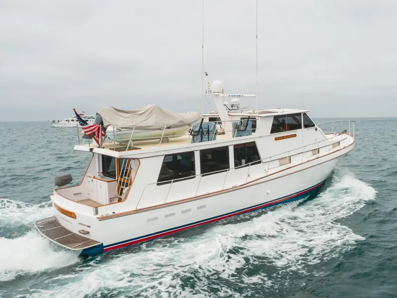 Slide: The Image of 1984 Vic Franck pilothouse yacht cruising on open water, featuring sleek design and American flag. - 21
