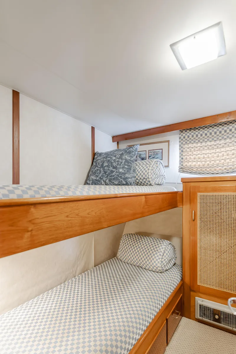Slide: The Image of Cozy bunk beds in 1984 Vic Franck pilothouse with patterned bedding and wooden accents. - 34