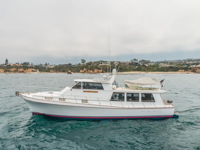 Slide: The Image of 1984 Vic Franck pilothouse yacht cruising near a scenic coastline. - 4