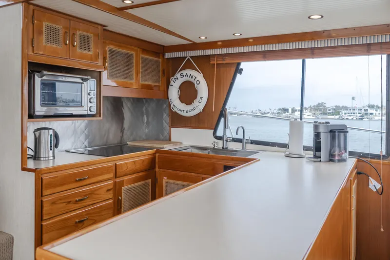 Slide: The Image of 1984 Vic Franck pilothouse kitchen with wooden cabinets, modern appliances, and ocean view. - 48