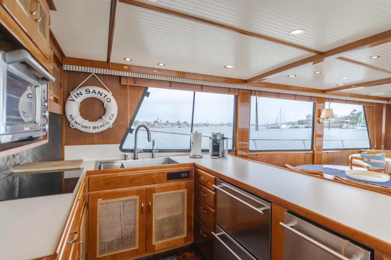 Slide: The Image of 1984 Vic Franck pilothouse interior with wooden cabinetry, large windows, and ocean view. - 49