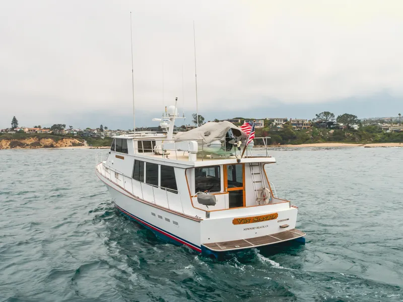 Slide: The Image of 1984 Vic Franck pilothouse yacht cruising near a scenic coastline. - 5