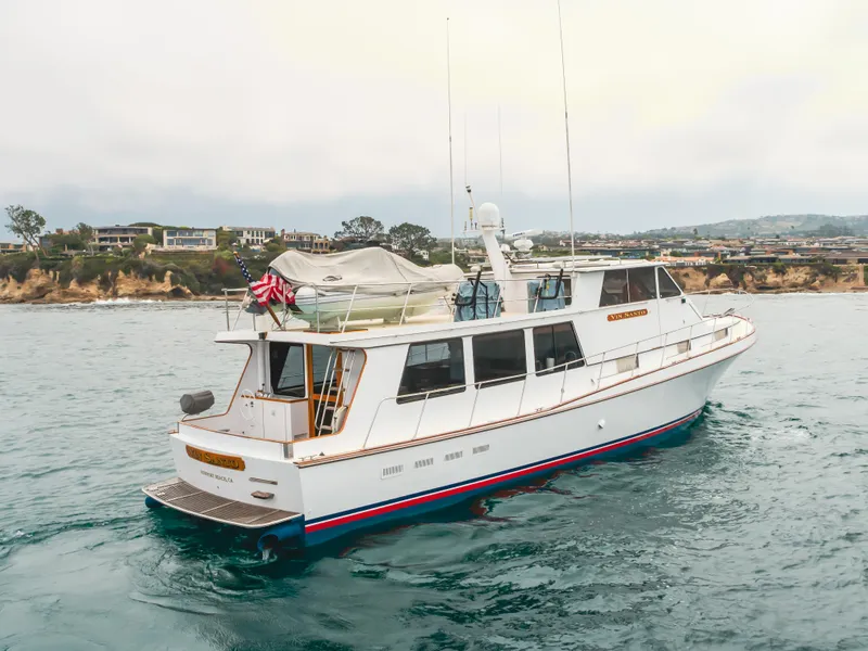 Slide: The Image of 1984 Vic Franck pilothouse yacht on ocean near coastal homes. - 7