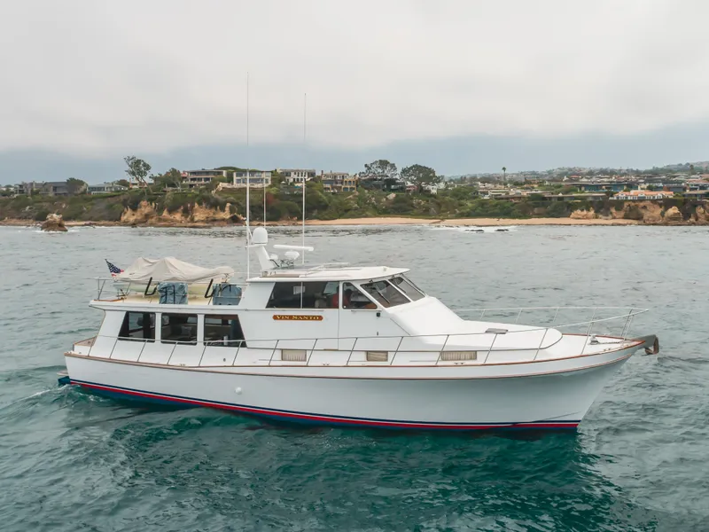 Slide: The Image of 1984 Vic Franck pilothouse yacht cruising near a scenic coastal landscape. - 9