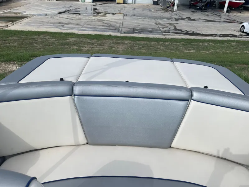 Slide: The Image of 2009 Sea Ray 175 Sport boat interior with cushioned seating, parked on grass. - 12