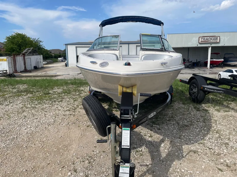 Slide: The Image of 2009 Sea Ray 175 Sport boat on trailer, parked outdoors near a warehouse. - 3