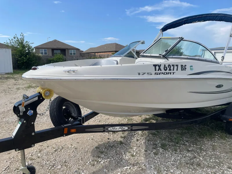 Slide: The Image of 2009 Sea Ray 175 Sport boat on trailer, parked outdoors under clear sky. - 4