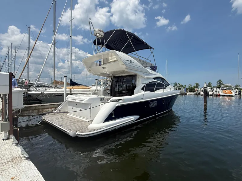 Slide: The Image of 2018 Azimut 42 Fly yacht docked at a marina under a clear blue sky. - 3