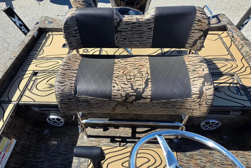 Slide: The Image of 2026 Xpress X23 Bay boat interior with camo seats and steering wheel. - 18
