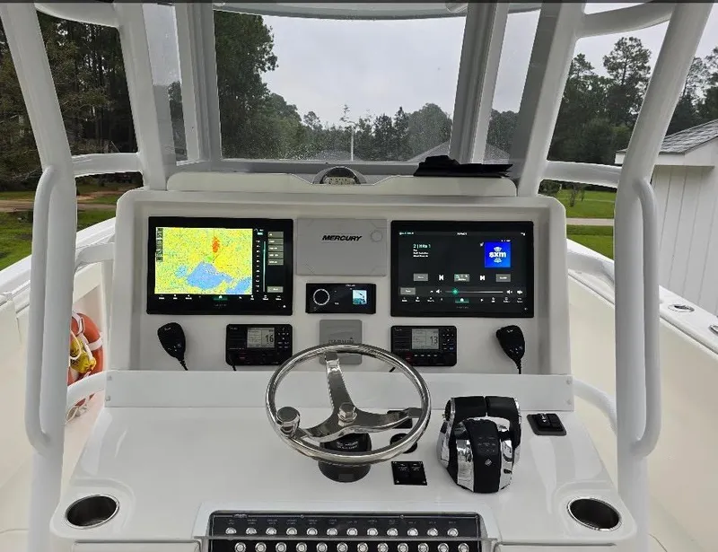 Slide: The Image of 2022 Invincible 33 Catamaran helm with navigation screens and controls. - 7