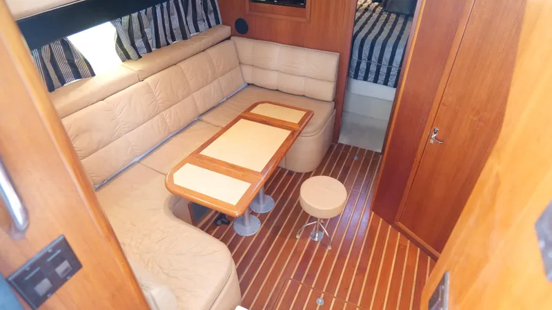 Slide: The Image of Interior of 2000 Tiara Yachts 3700 Open with seating, table, and striped curtains. - 28