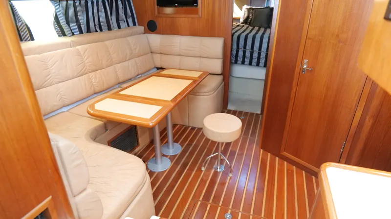 Slide: The Image of Interior of 2000 Tiara Yachts 3700 Open with cozy seating and wooden flooring. - 29