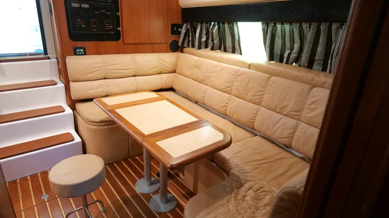 Slide: The Image of Interior of 2000 Tiara Yachts 3700 Open with beige seating and wooden table. - 31