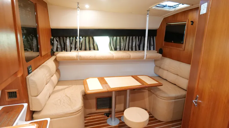 Slide: The Image of Interior of 2000 Tiara Yachts 3700 Open, featuring cozy seating and wooden accents. - 32
