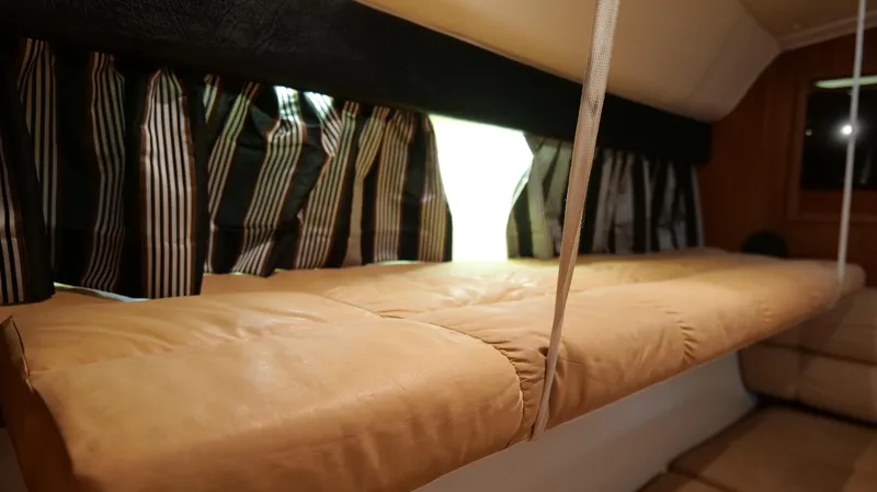 Slide: The Image of Interior cabin of 2000 Tiara Yachts 3700 Open with striped curtains and cushioned seating. - 33