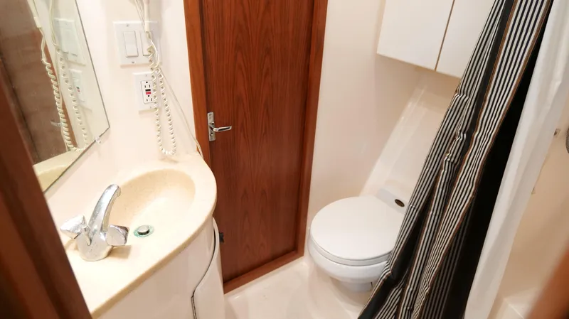 Slide: The Image of Bathroom interior of 2000 Tiara Yachts 3700 Open, featuring sink, toilet, and shower curtain. - 40