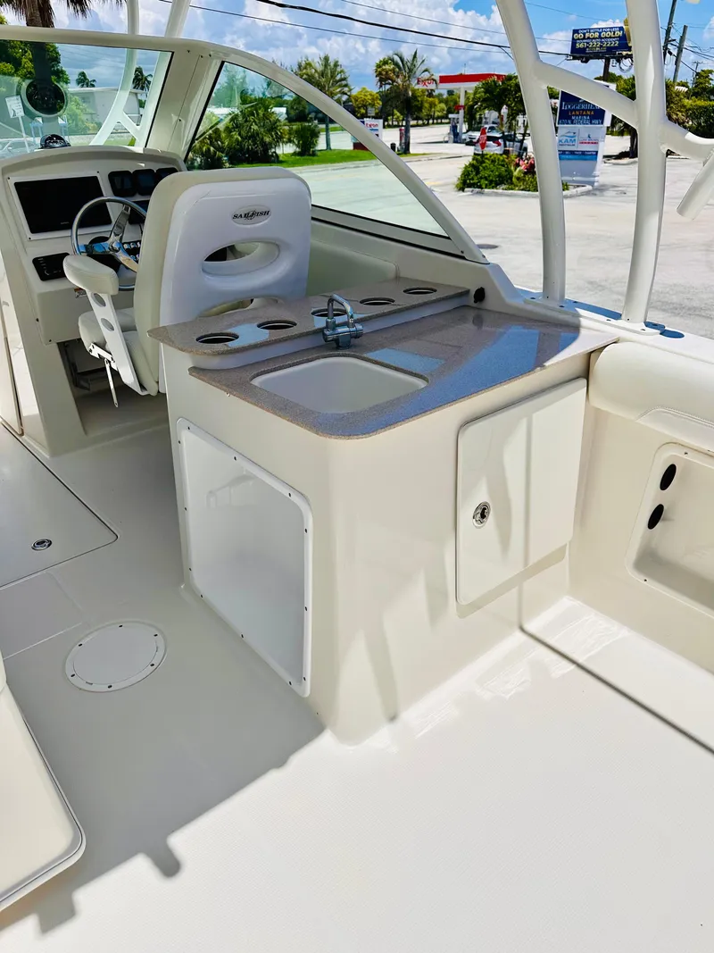 Slide: The Image of 2014 Sailfish 275 DC boat interior with helm, sink, and seating area. - 11