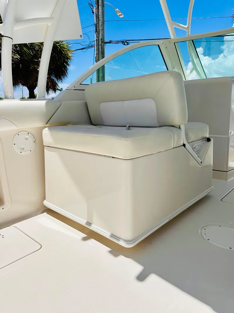Slide: The Image of 2014 Sailfish 275 DC boat interior with white seating under clear blue sky. - 12