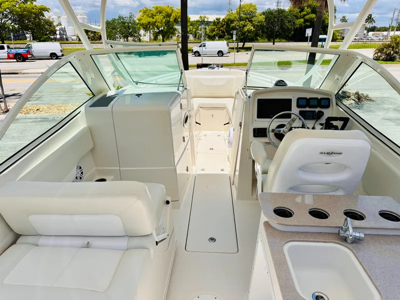 Slide: The Image of 2014 Sailfish 275 DC boat interior with helm, seating, and sink, showcasing modern design. - 13