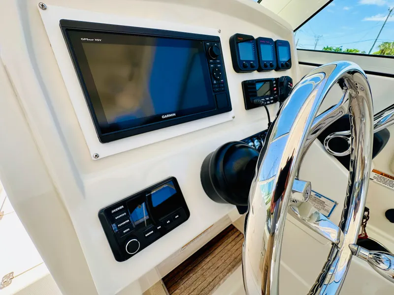 Slide: The Image of Control panel of 2014 Sailfish 275 DC boat with Garmin GPS and steering wheel. - 16