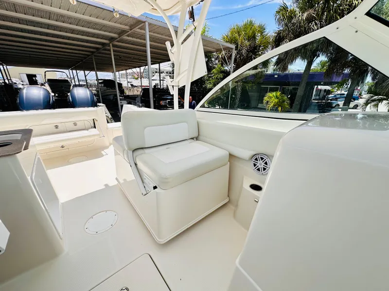 Slide: The Image of 2014 Sailfish 275 DC boat interior with white seating and canopy. - 18