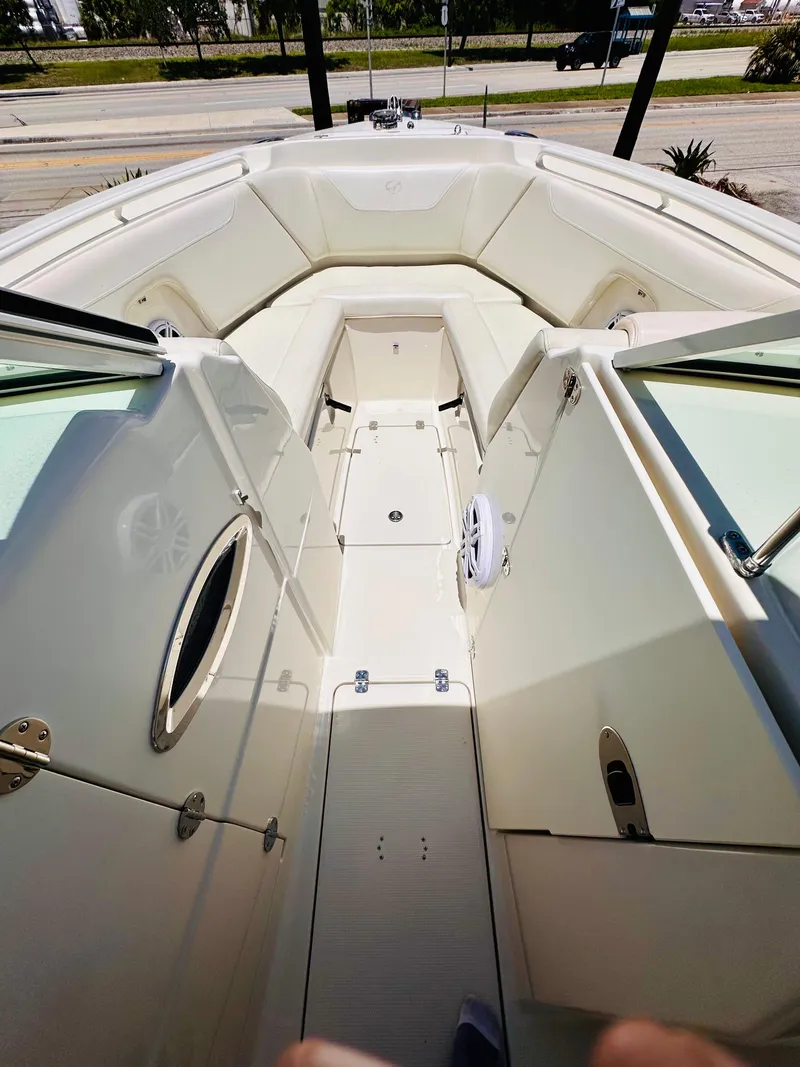 Slide: The Image of 2014 Sailfish 275 DC boat interior with white seating and open deck view. - 20