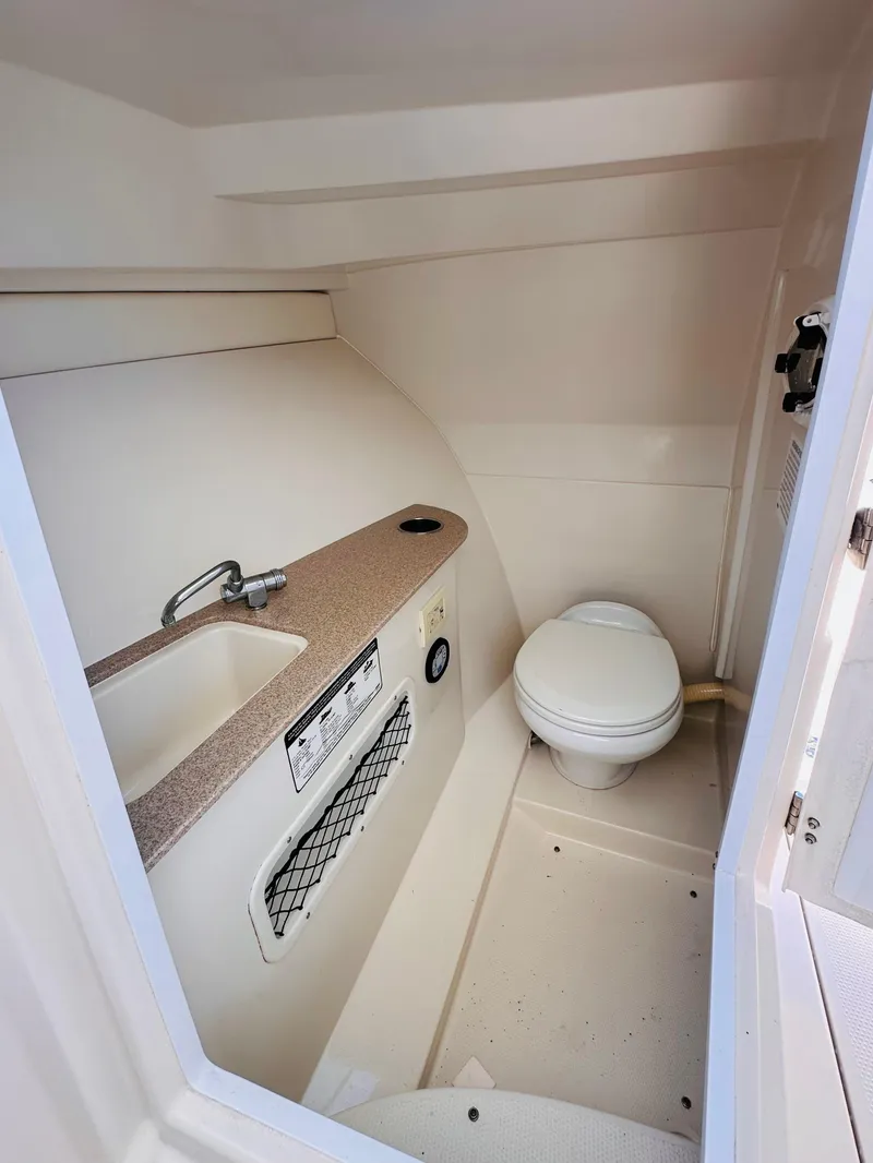 Slide: The Image of Compact bathroom in 2014 Sailfish 275 DC boat with sink and toilet. - 23