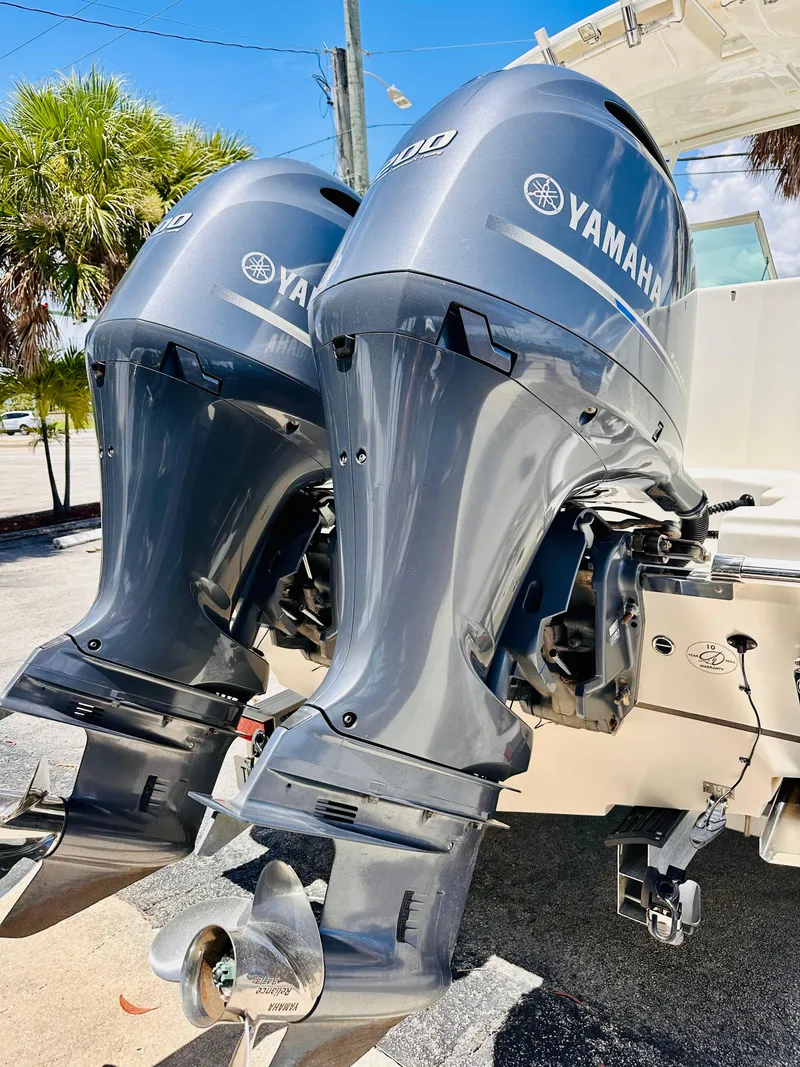 Slide: The Image of Twin Yamaha outboard engines on a 2014 Sailfish 275 DC boat, parked outdoors. - 3
