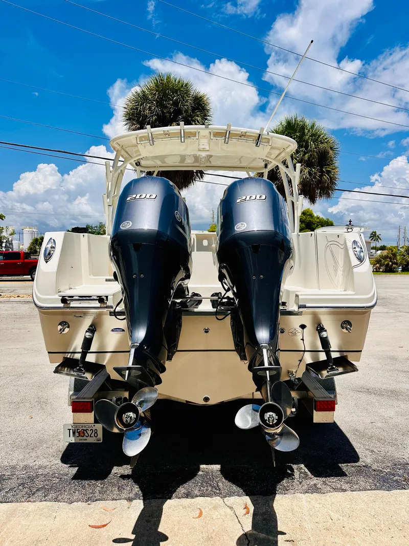 Slide: The Image of 2014 Sailfish 275 DC boat with dual 200 horsepower engines, parked under a clear blue sky. - 4