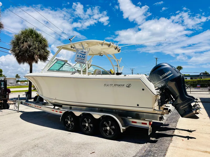 Slide: The Image of 2014 Sailfish 275 DC boat on trailer, sunny day, palm trees, Yamaha engine. - 6