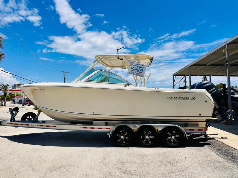 Slide: The Image of 2014 Sailfish 275 DC boat on trailer under clear blue sky. - 7