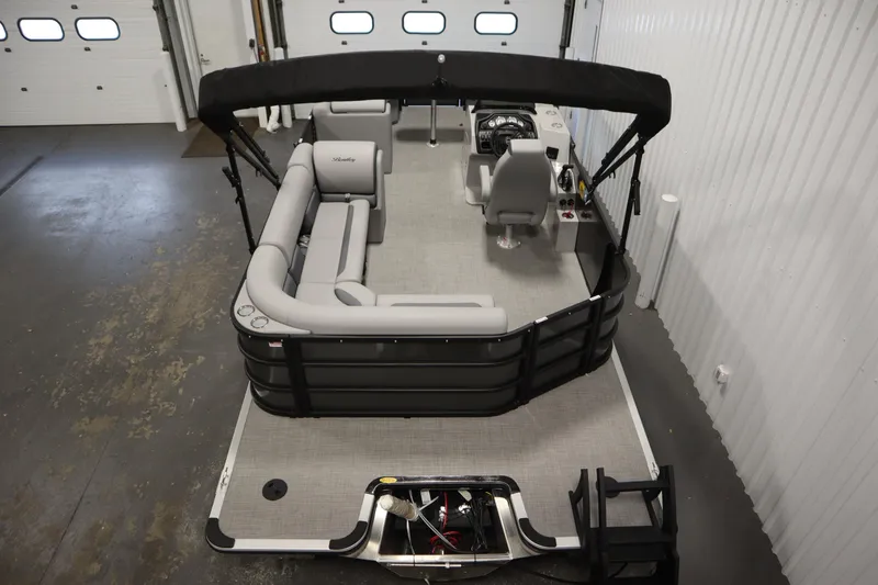 Slide: The Image of 2025 Bentley Pontoons 220 Cruise XL interior with seating and helm, in a garage setting. - 6