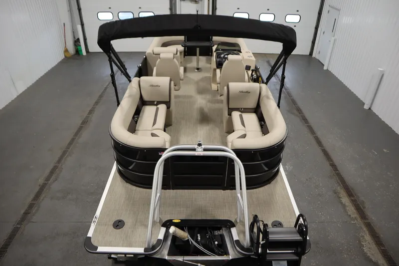 Slide: The Image of 2026 Bentley Pontoons 220 Navigator, spacious interior, beige seating, black exterior, indoor setting. - 9