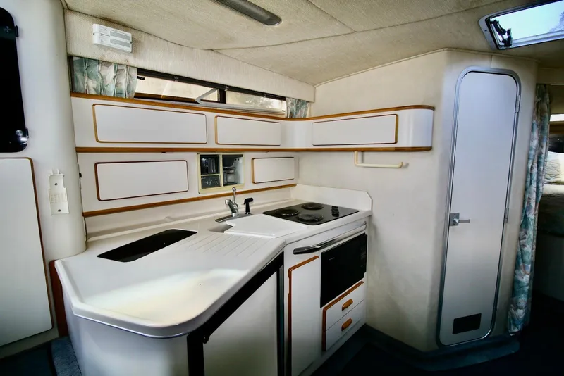 Slide: The Image of Interior view of 1993 Sea Ray 370 Sundancer yacht kitchen with stove and cabinets. - 12
