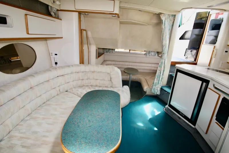 Slide: The Image of Interior of 1993 Sea Ray 370 Sundancer yacht with plush seating and compact kitchenette. - 15