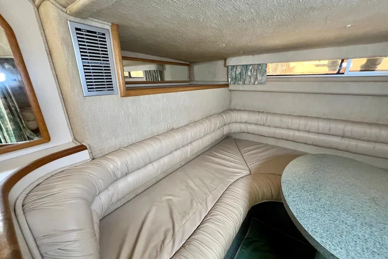 Slide: The Image of Interior of 1993 Sea Ray 370 Sundancer with beige seating and round table. - 18