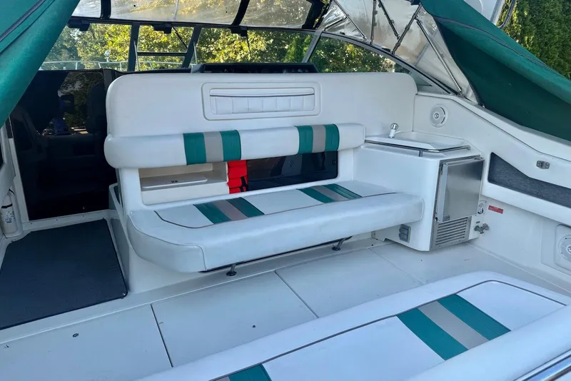 Slide: The Image of 1993 Sea Ray 370 Sundancer interior with white and green seating, mini fridge, and sink. - 5