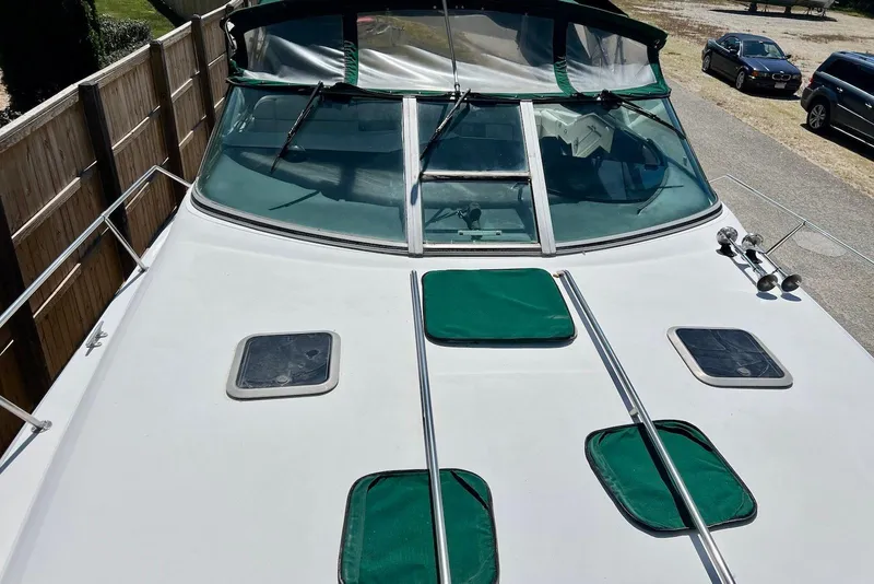 Slide: The Image of 1993 Sea Ray 370 Sundancer boat with green covers and windshield, parked outdoors. - 9