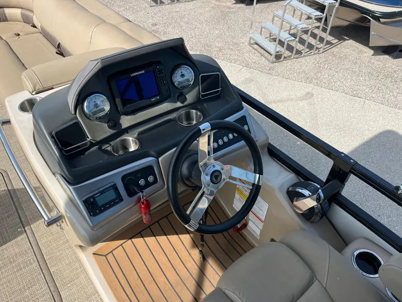 Slide: The Image of 2019 Regency 230 LE3 boat dashboard with steering wheel and navigation controls. - 10