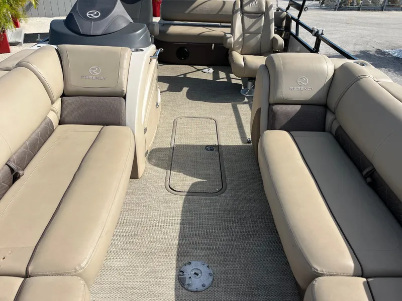 Slide: The Image of 2019 Regency 230 LE3 boat interior with beige seating and carpeted floor. - 15