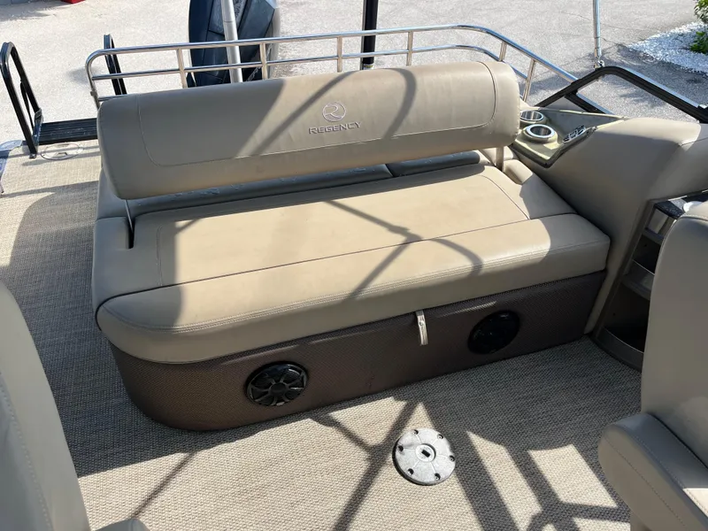 Slide: The Image of 2019 Regency 230 LE3 boat interior with beige seating and speaker system. - 18