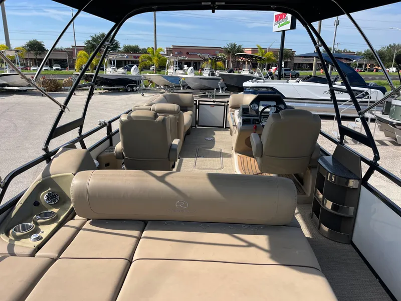 Slide: The Image of 2019 Regency 230 LE3 pontoon boat interior with seating and helm, displayed outdoors. - 9