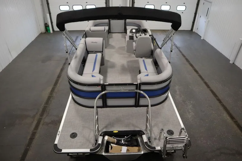 Slide: The Image of 2025 Bentley Pontoons 223 Bolt Tri-Toon in a garage, showcasing spacious seating and modern design. - 12